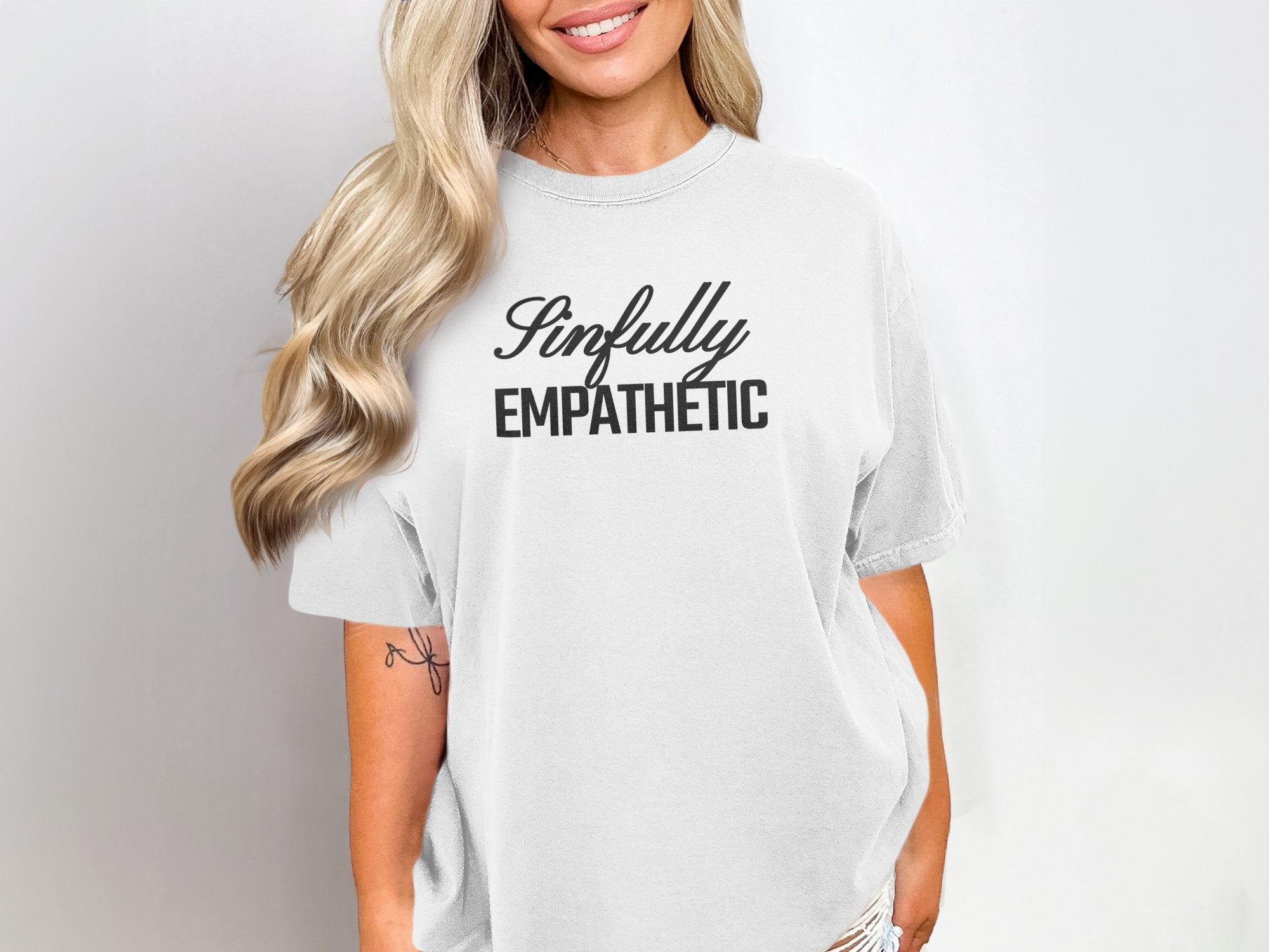 a woman wearing a white t - shirt with the words empathetic printed on