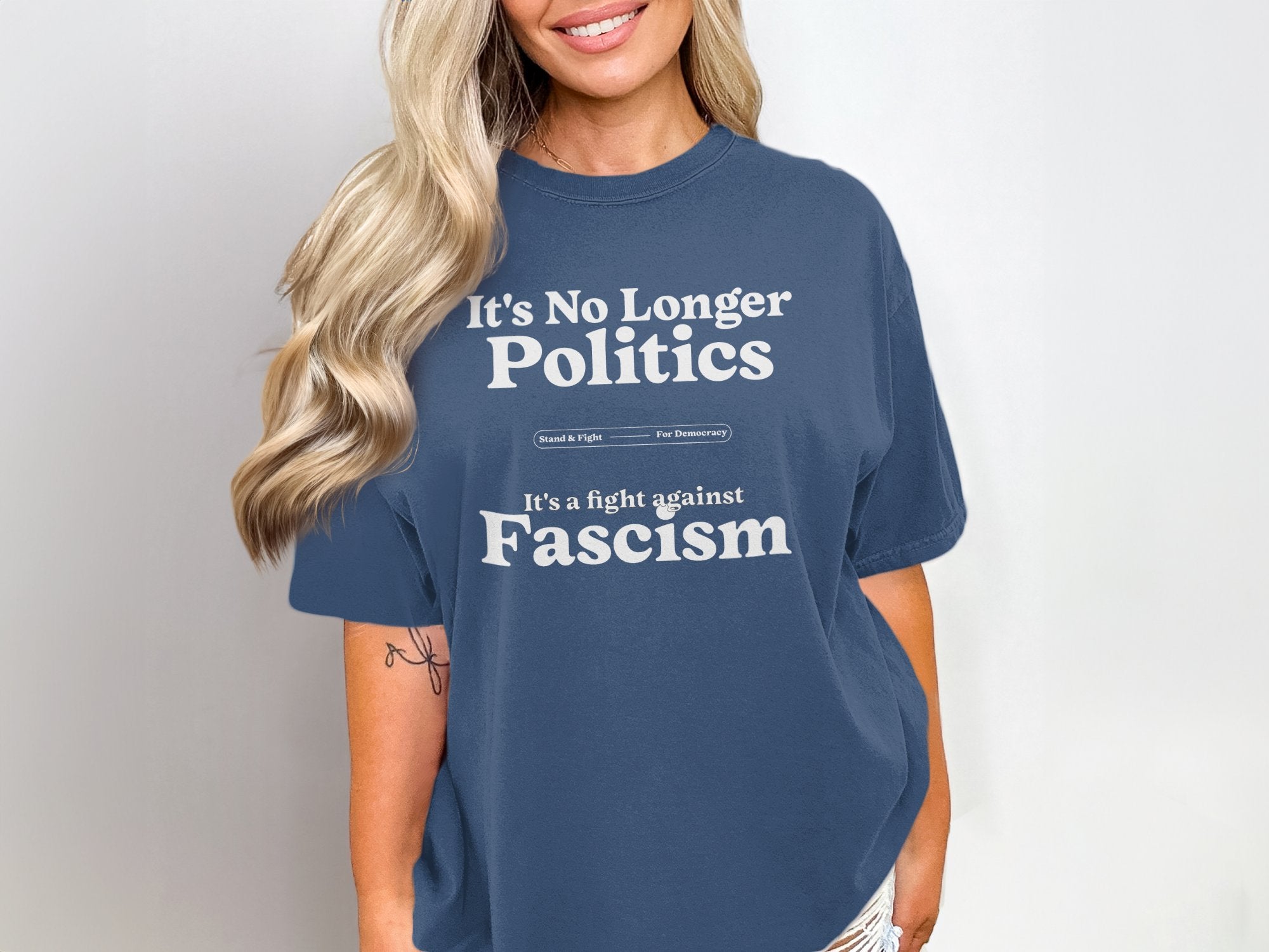 a woman wearing a blue t - shirt that says it's no longer politics