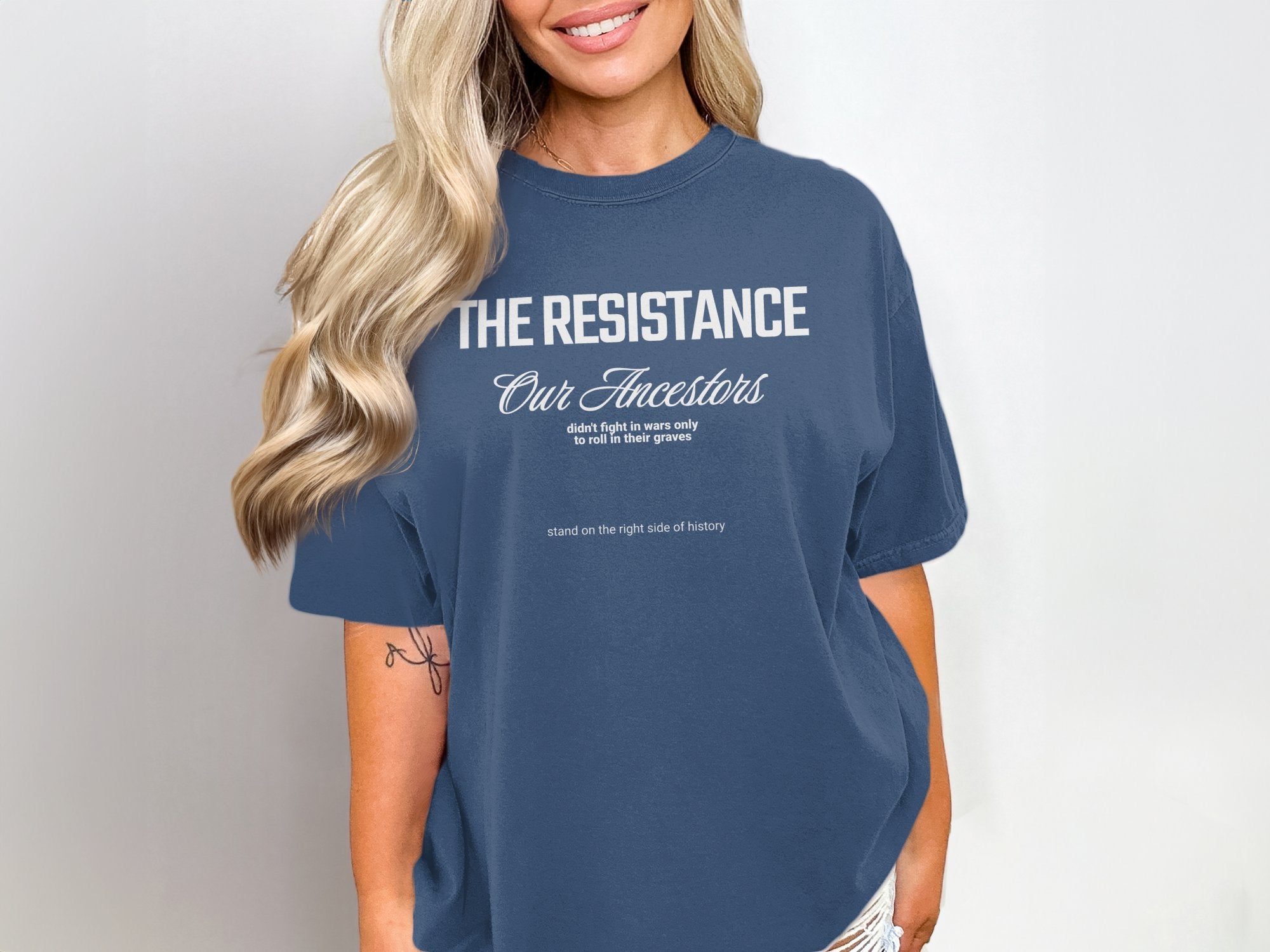 a woman wearing a blue t - shirt with the words the resistance on it