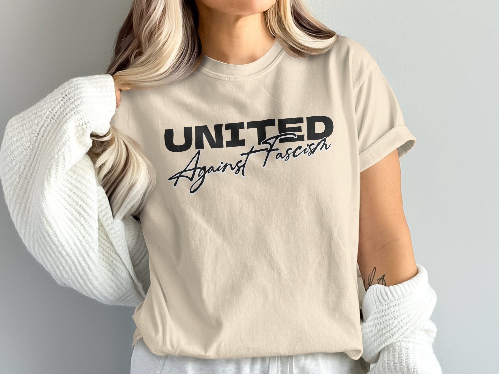 a woman wearing a united against racism t - shirt