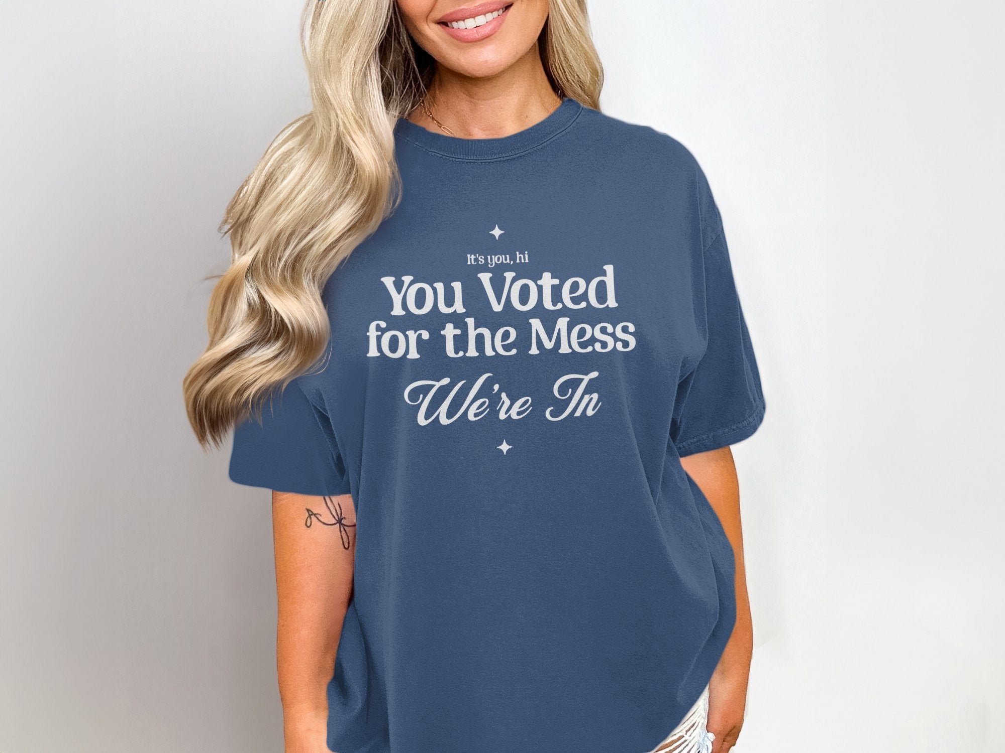 a woman wearing a t - shirt that says, you vote for the mess we